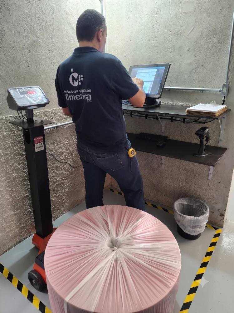 Operario utilizando terminal táctil industrial de pesaje y control en planta